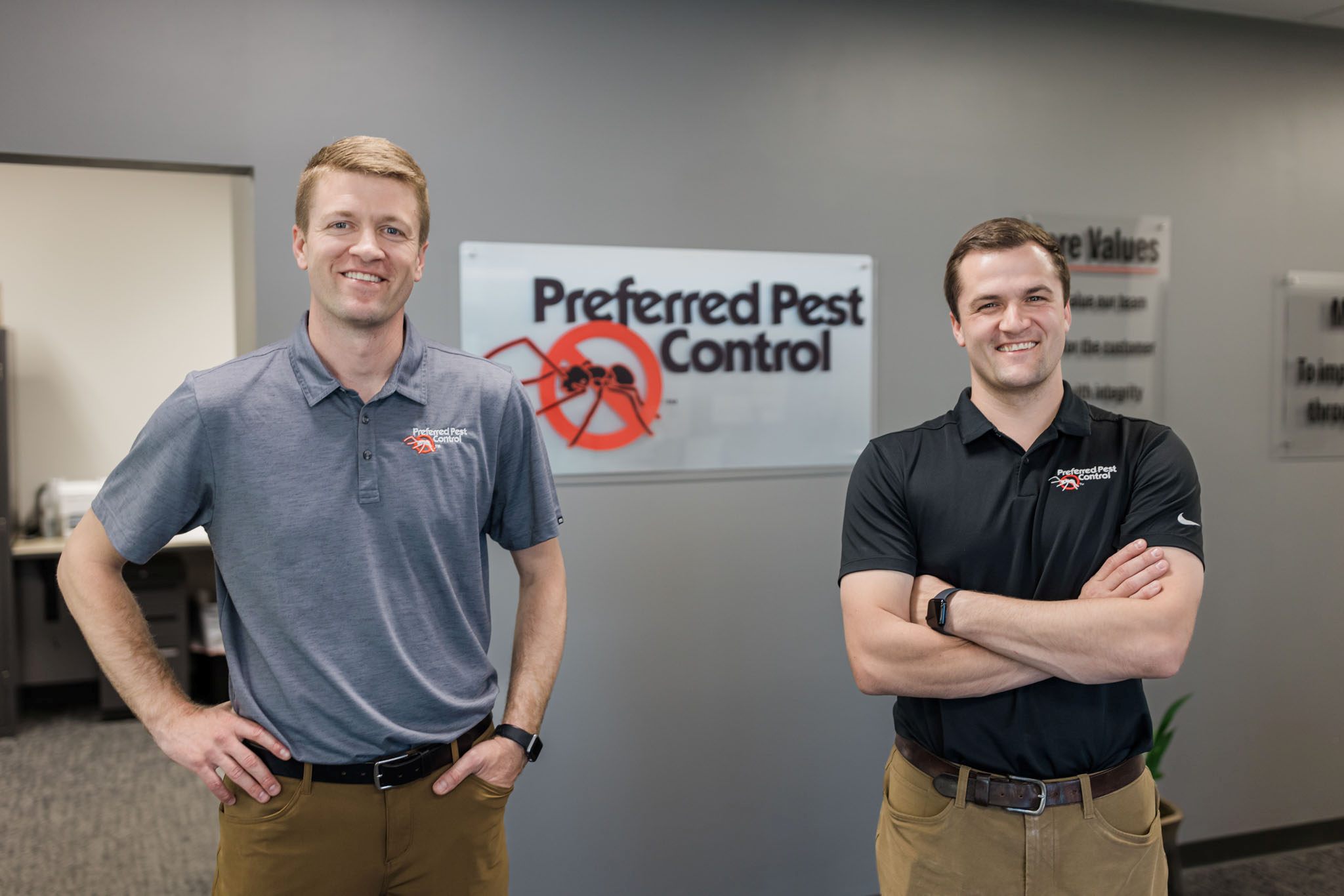 preferred pest employees in front of sign
